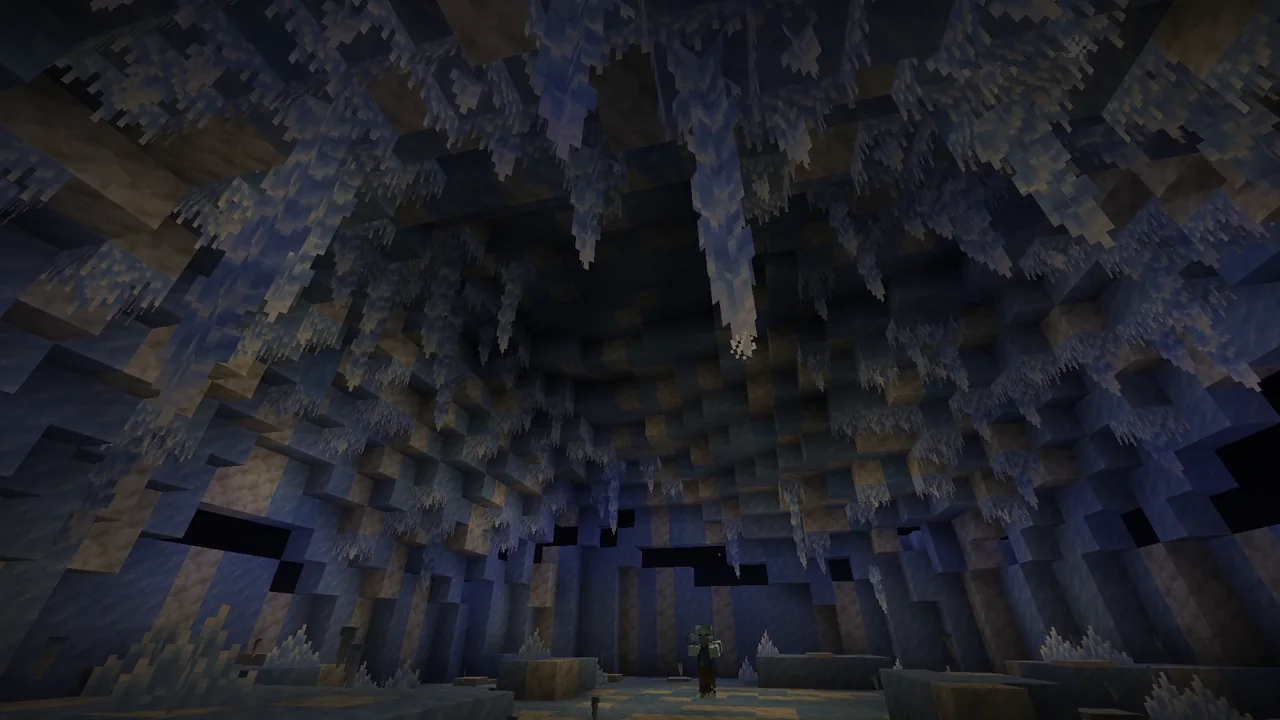 Techo de una cueva de hielo cubierto de carámbanos colgantes de distintos tamaños, con paredes azules y calcita